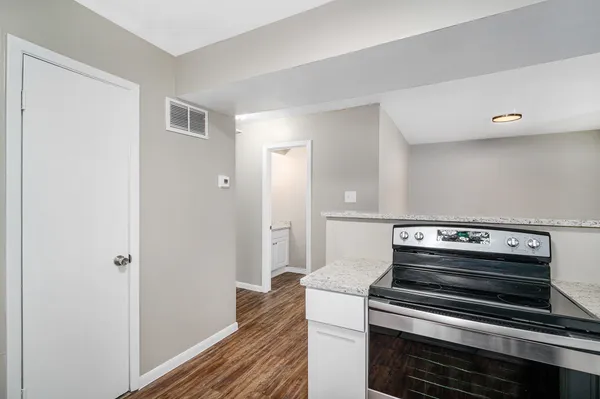 a kitchen with wooden floor and a stove top oven