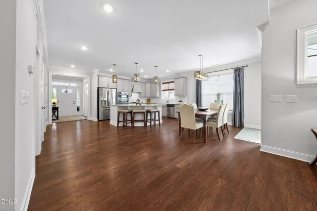 a view of a hallway with wooden floor and a bathroom