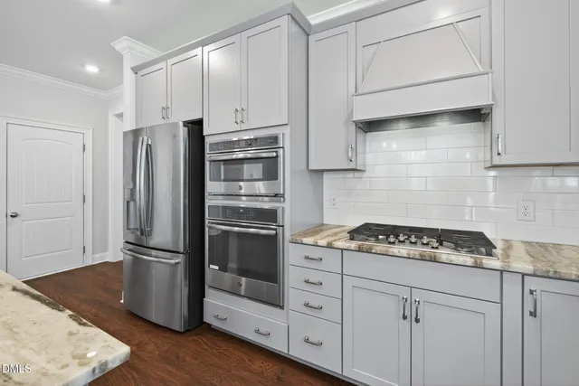 a kitchen with stove and wooden floor