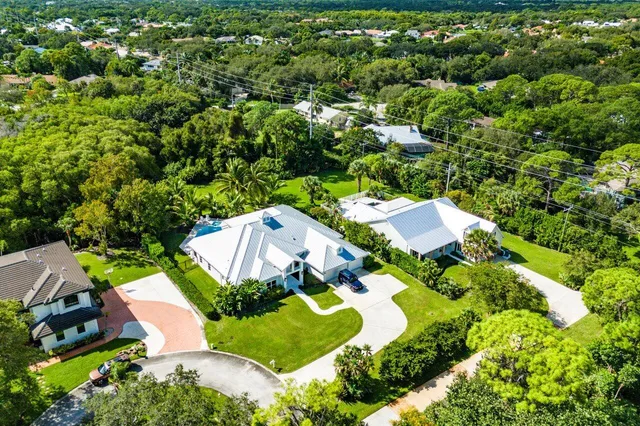 an aerial view of a house with a yard and lake view