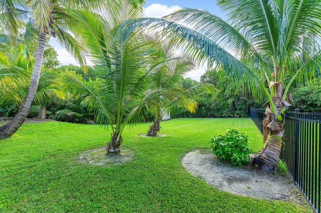 an aerial view of residential house with outdoor space and trees all around