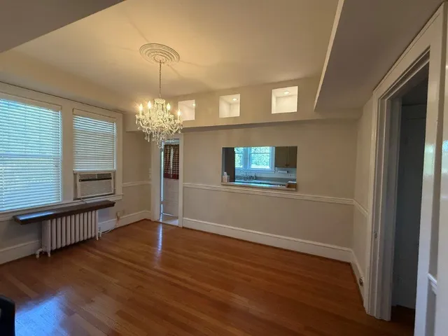 a view of a livingroom with wooden floor and a large window