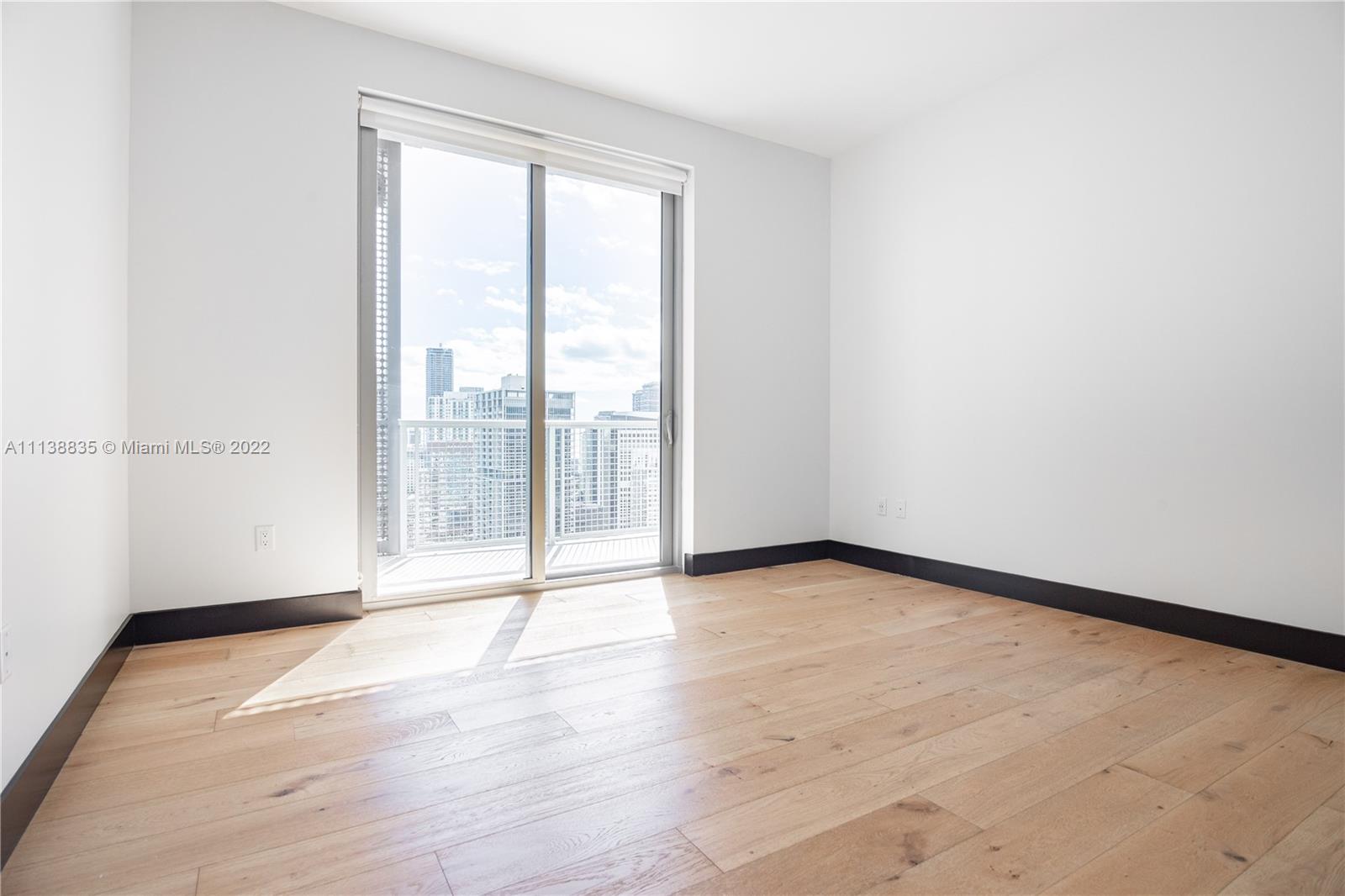 340 Southeast 3rd Street, Unit PH4 Miami, FL 33131 - Photo 11 of 62 a view of an empty room with wooden floor and a window