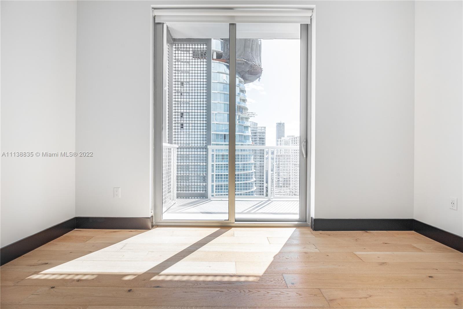 340 Southeast 3rd Street, Unit PH4 Miami, FL 33131 - Photo 15 of 62 a view of an empty room with wooden floor and a window