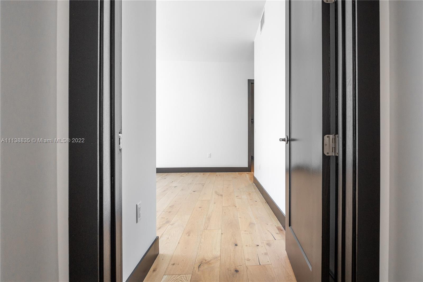 340 Southeast 3rd Street, Unit PH4 Miami, FL 33131 - Photo 22 of 62 a view of a hallway with wooden floor and a bathroom