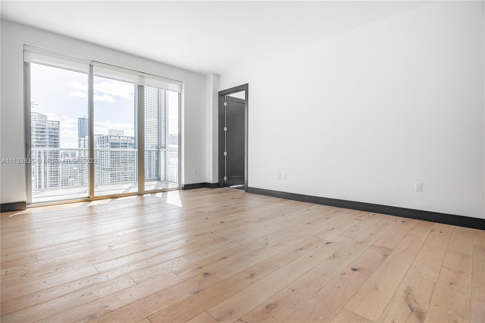 340 Southeast 3rd Street, Unit PH4 Miami, FL 33131 - Photo 23 of 62 a view of an empty room with wooden floor and a window