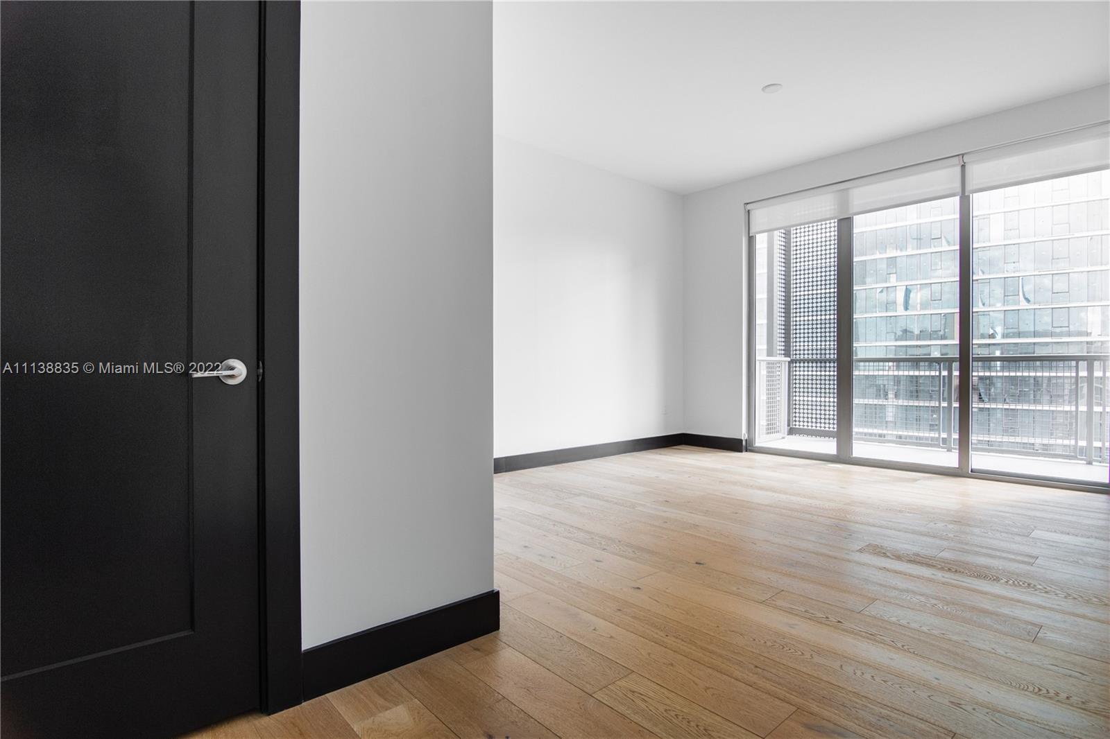 340 Southeast 3rd Street, Unit PH4 Miami, FL 33131 - Photo 47 of 62 wooden floor in an empty room with a window