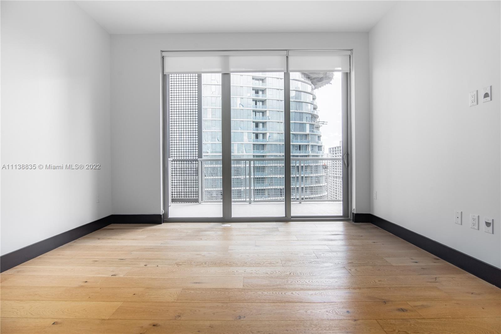 340 Southeast 3rd Street, Unit PH4 Miami, FL 33131 - Photo 48 of 62 a view of an empty room with wooden floor and a window