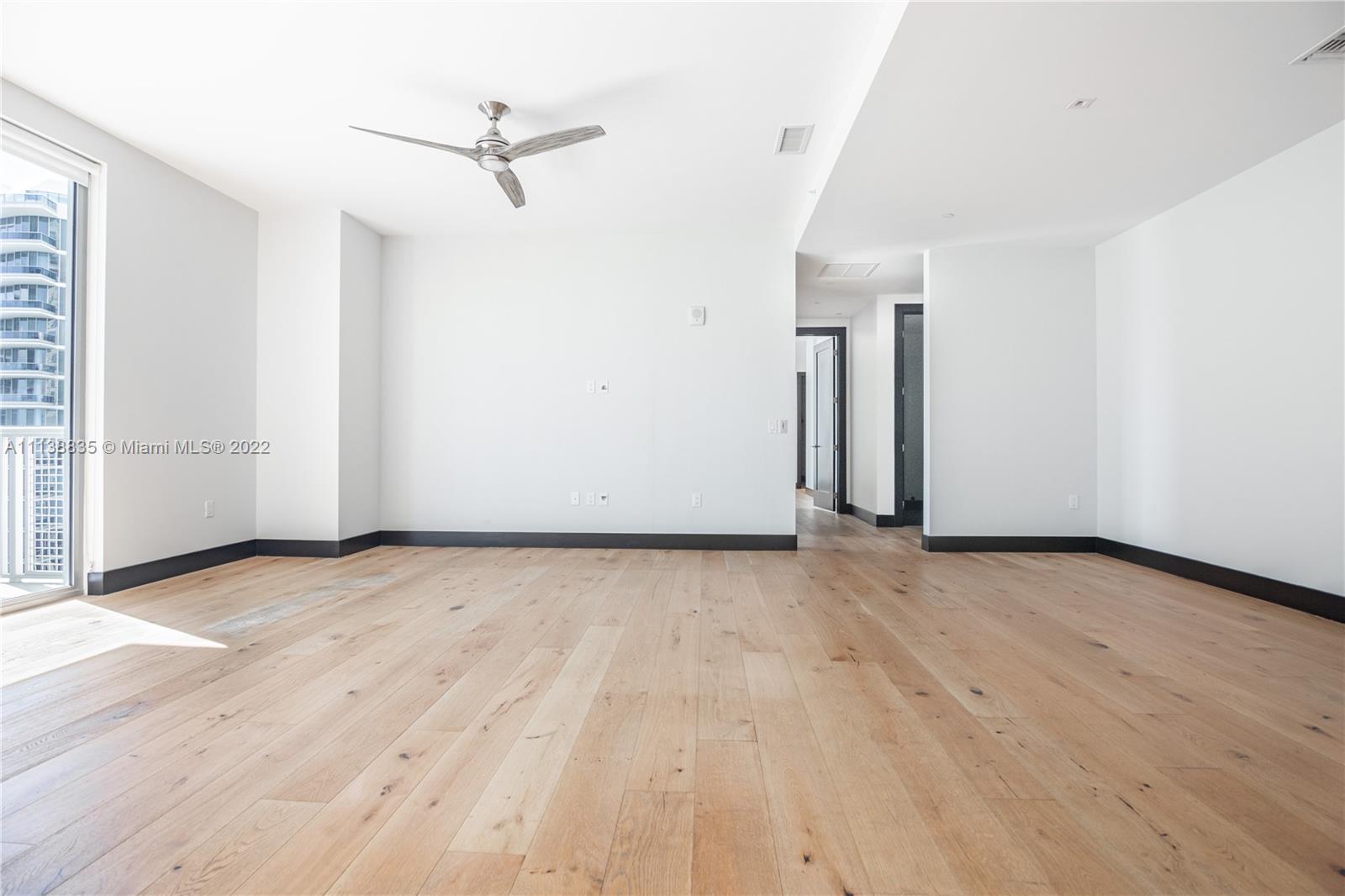 340 Southeast 3rd Street, Unit PH4 Miami, FL 33131 - Photo 5 of 62 an empty room with wooden floor and ceiling fan
