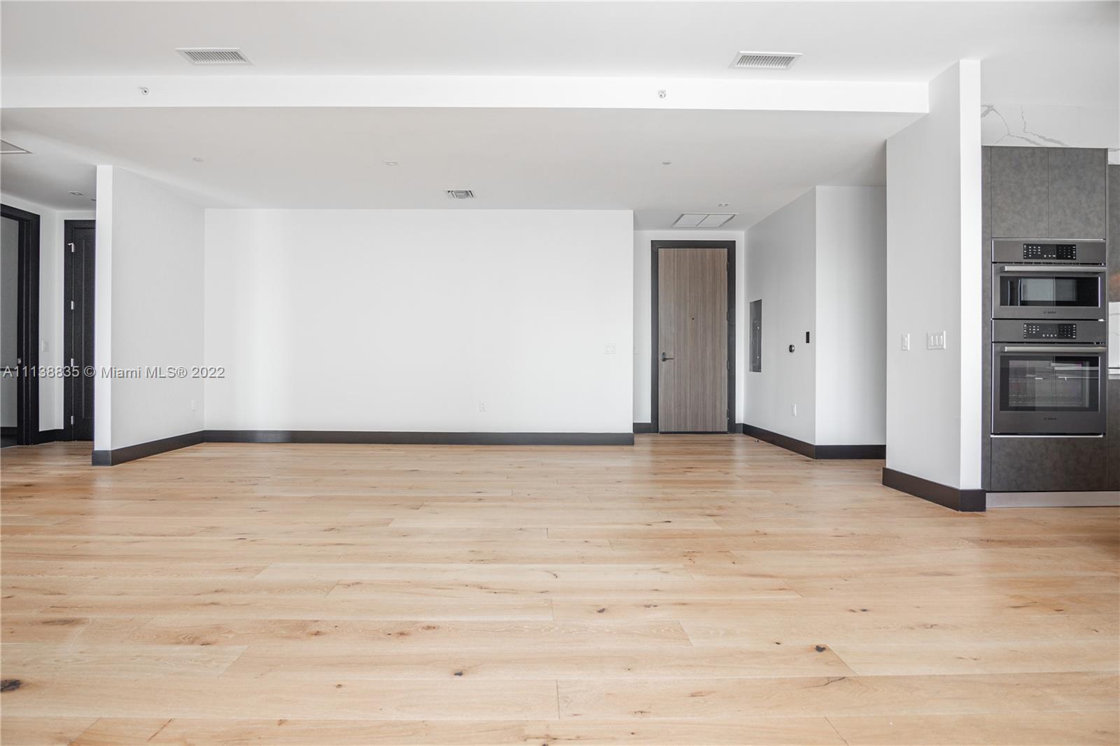 340 Southeast 3rd Street, Unit PH4 Miami, FL 33131 - Photo 6 of 62 a view of empty room with wooden floor