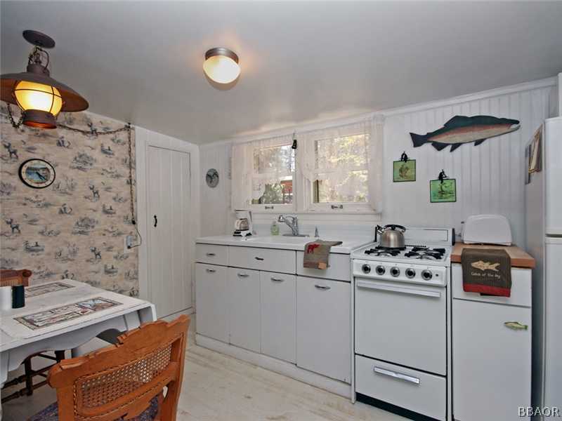 1004 Canyon Road Fawnskin, CA 92333 - Photo 16 of 25 a kitchen that has a cabinets and a stove in it