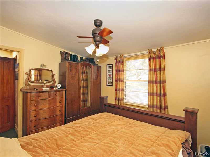 1004 Canyon Road Fawnskin, CA 92333 - Photo 22 of 25 a bedroom with a bed and a chandelier