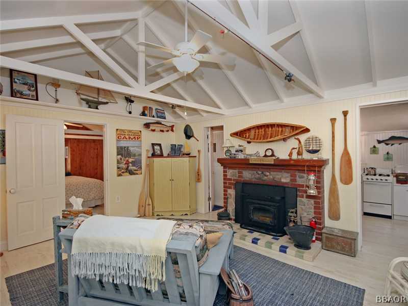 1004 Canyon Road Fawnskin, CA 92333 - Photo 6 of 25 a bedroom with a bed a fireplace and a chandelier