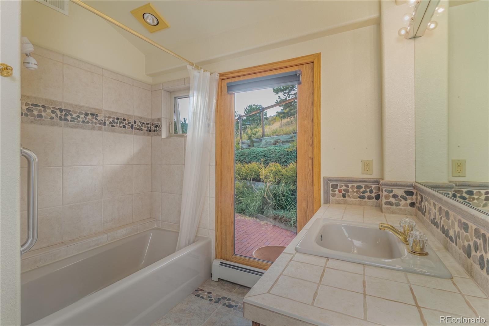 265 Bellevue Drive Boulder, CO 80302 - Photo 25 of 32 a bathroom with a granite countertop sink a mirror and a bathtub