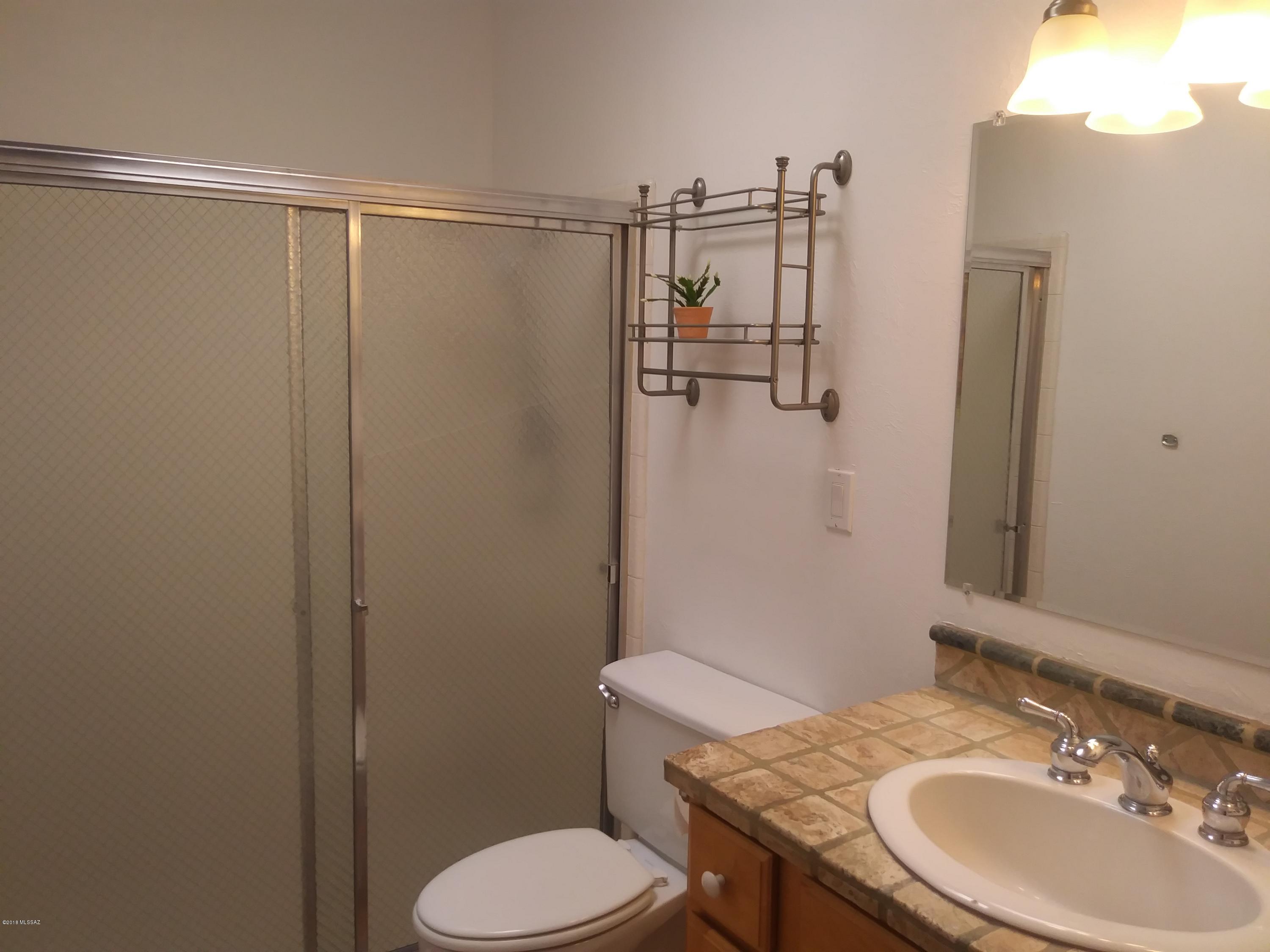 600 East River Road, Unit 1 Tucson, AZ 85704 - Photo 15 of 21 a bathroom with a granite countertop toilet sink and shower
