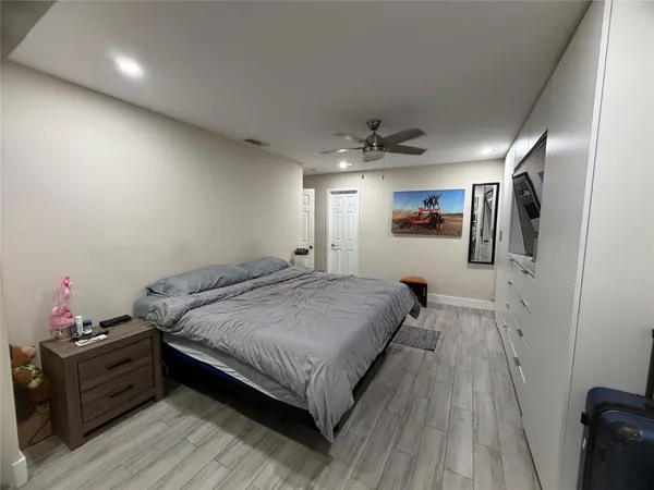 a spacious bedroom with a bed and wooden floor