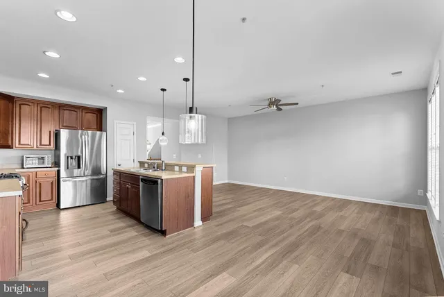 a large kitchen with a wooden floor and stainless steel appliances