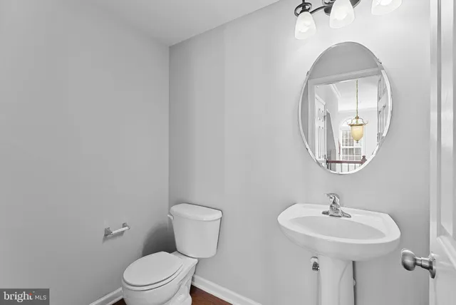 a bathroom with a toilet a sink and mirror