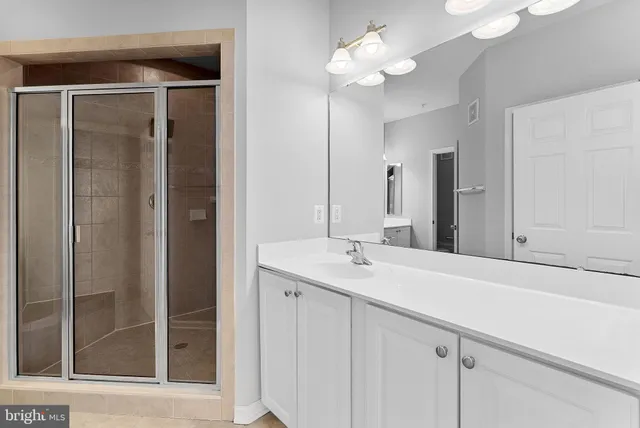 a bathroom with a sink vanity and a mirror