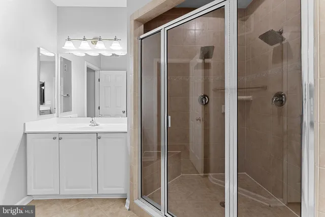 a bathroom with a glass shower door and a sink
