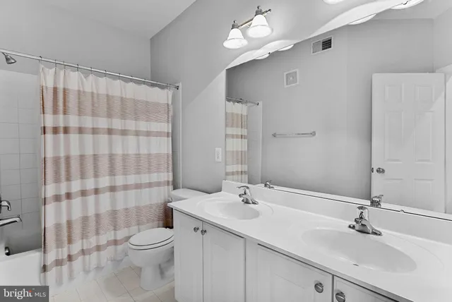 a bathroom with a double vanity sink toilet and shower