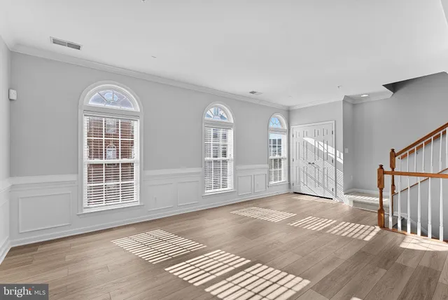 a view of an empty room with glass door and windows