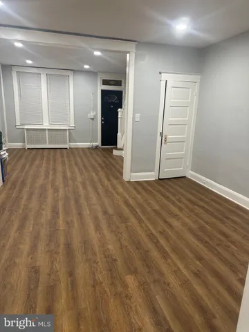 an empty room with wooden floor and a ceiling fan
