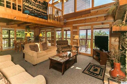 1758 Bluff Ridge Road Sevierville, TN 37876 - Photo 2 of 13 a living room with furniture a flat screen tv and floor to ceiling windows