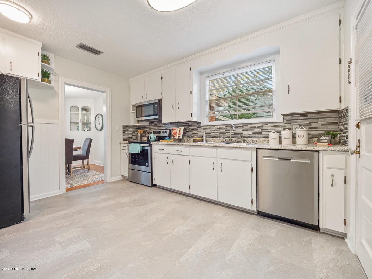3981 Gadsden Road Jacksonville, FL 32207 - Photo 18 of 34 a kitchen with white cabinets stainless steel appliances and a window