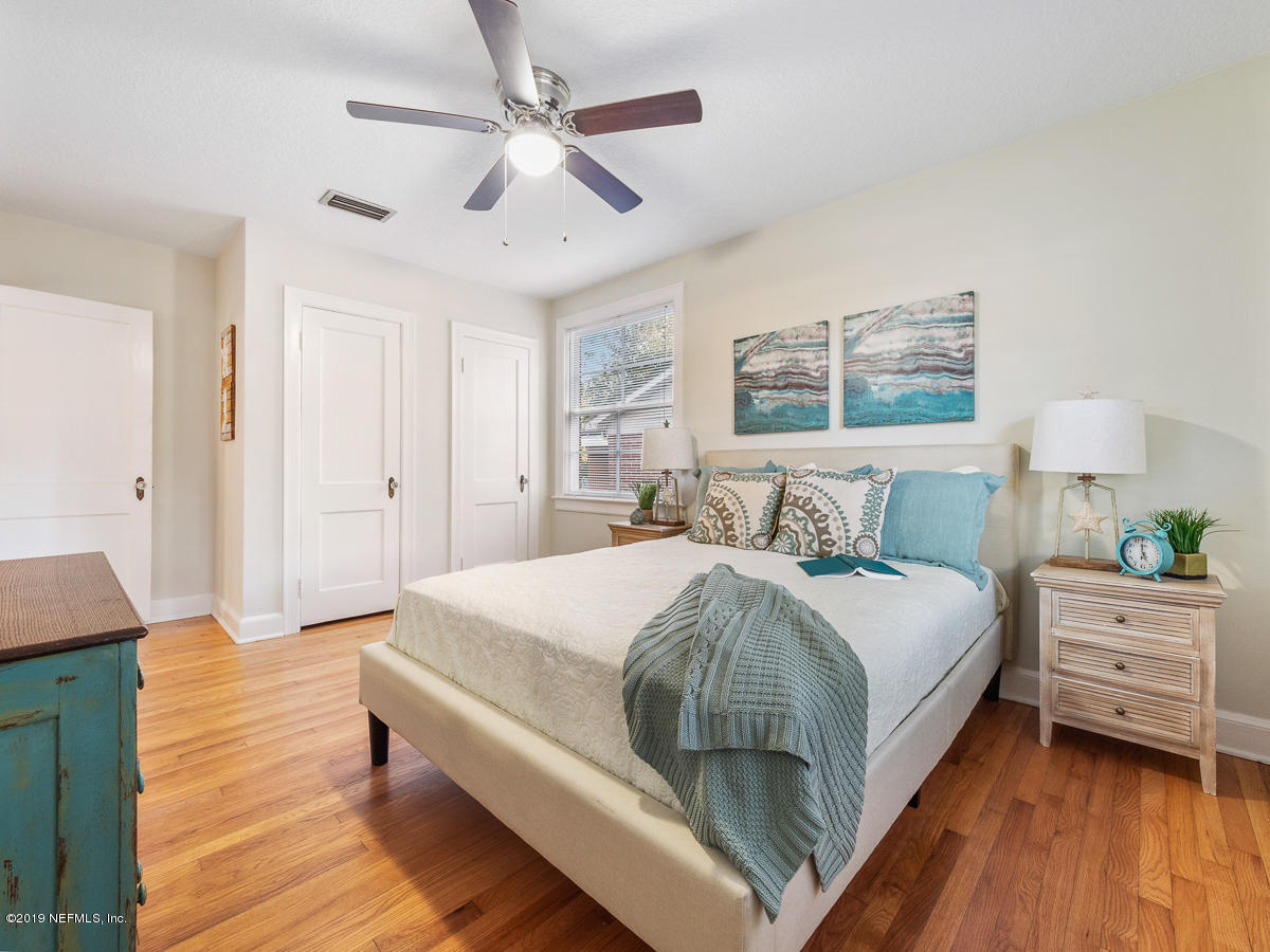 3981 Gadsden Road Jacksonville, FL 32207 - Photo 26 of 34 a spacious bedroom with a bed and a chandelier