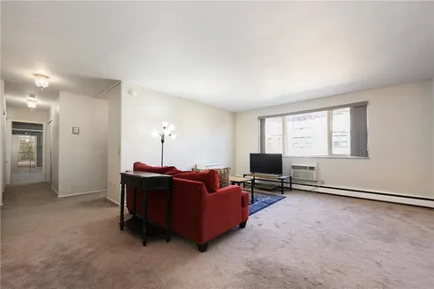 a living room with furniture a flat screen tv and a window