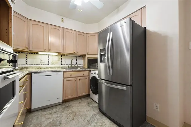 a kitchen with a refrigerator sink and cabinets