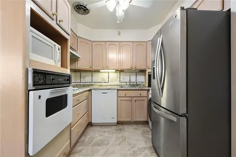 a kitchen with stainless steel appliances a refrigerator sink and cabinets