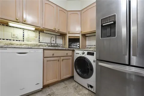 a kitchen with stainless steel appliances granite countertop a sink a stove and cabinets