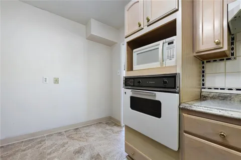 a kitchen with granite countertop white cabinets and white appliances
