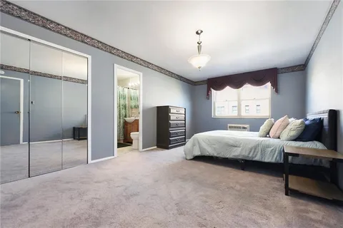 a spacious bedroom with a bed and glass walk in closet