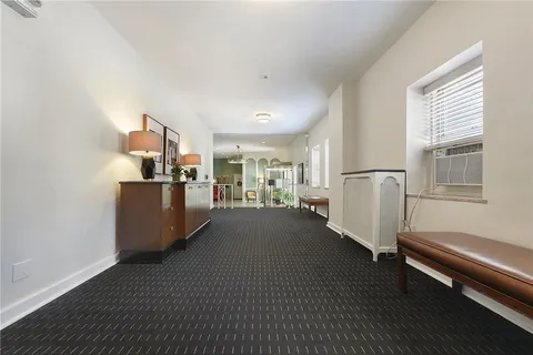 a living room with furniture and a refrigerator