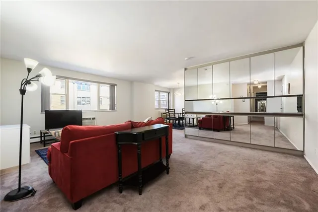 a living room with furniture a flat screen tv and windows