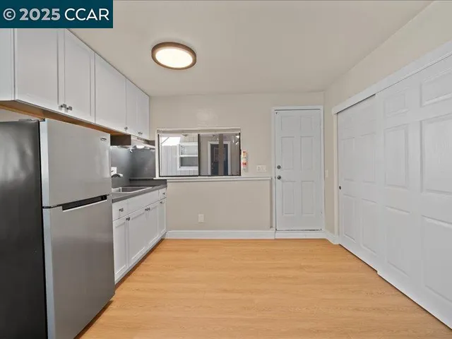 a view of a kitchen with a sink refrigerator and wooden floor