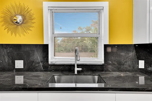 a kitchen with stainless steel appliances granite countertop a sink and a refrigerator