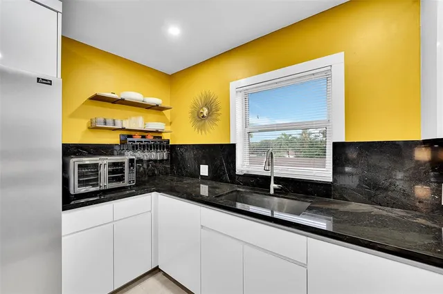 a view of a kitchen with a refrigerator a sink and dishwasher a refrigerator with wooden floor