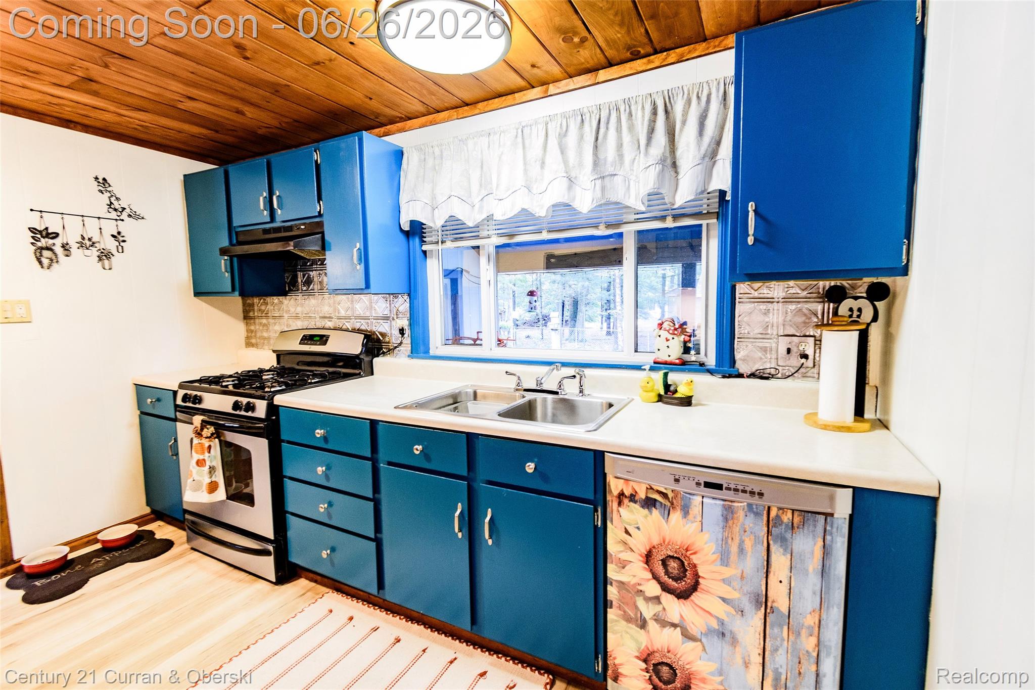 3270 Woods Road Harrison, MI 48625 - Photo 14 of 42 Kitchen featuring wood-finish ceiling, blue cabinetry, light-toned countertops, stainless steel gas range, and a double basin sink with a window above