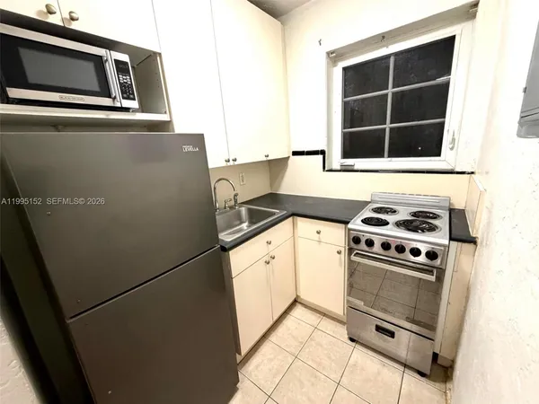 a kitchen with granite countertop a stove and a microwave