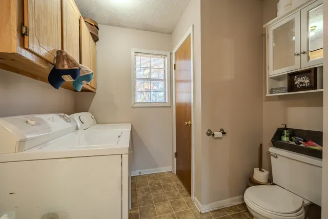 a bathroom with a toilet a sink and a window