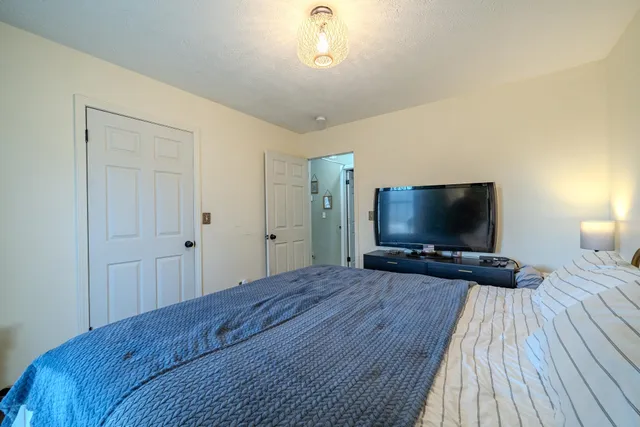 a bedroom with a bed and a flat screen tv