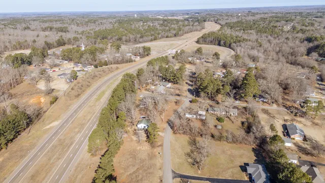 an aerial view of house with yard and mountain view in back