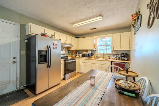 a kitchen with kitchen island white cabinets and refrigerator
