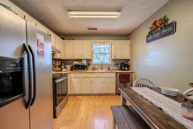 a kitchen with a refrigerator and a stove top oven