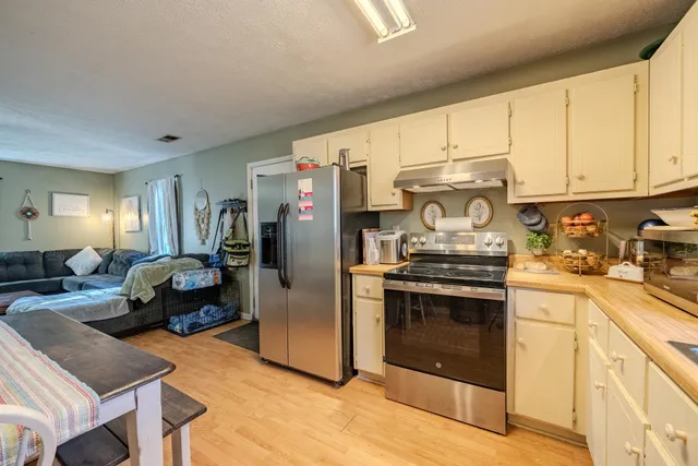 a kitchen with stainless steel appliances granite countertop a stove a sink and a refrigerator
