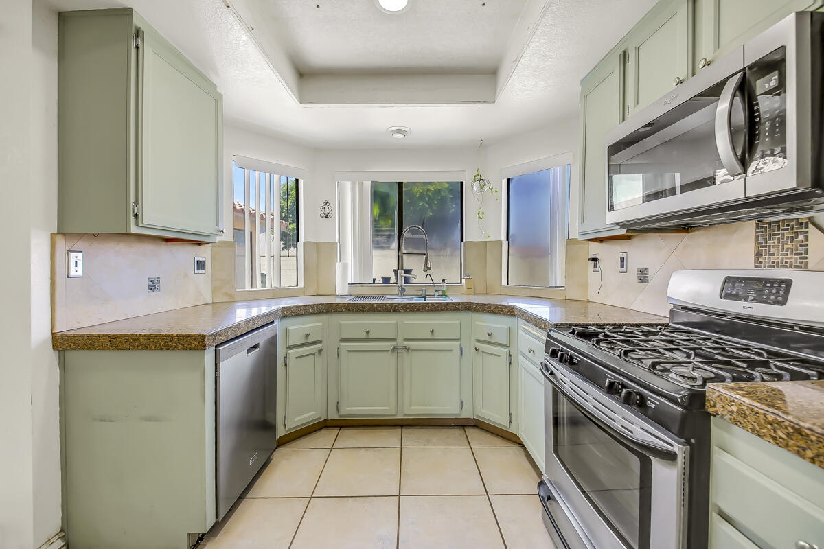 45535 Indian River Road Indio, CA 92201 - Photo 11 of 29 a kitchen with stainless steel appliances granite countertop a stove a sink and a microwave
